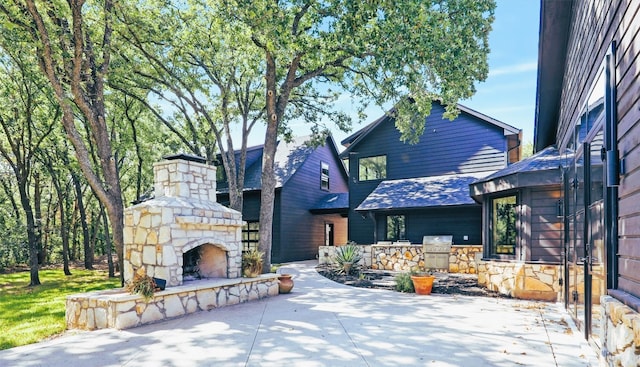 exterior space featuring a patio and an outdoor stone fireplace