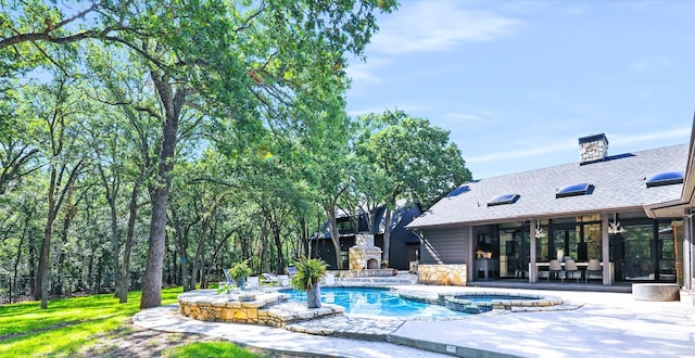 view of swimming pool featuring a patio area, an outdoor stone fireplace, and an in ground hot tub