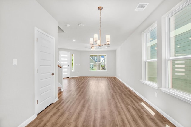 empty room featuring light hardwood / wood-style flooring and an inviting chandelier