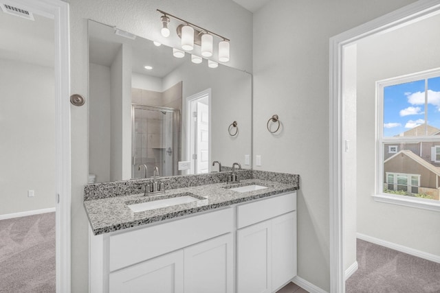 bathroom with dual vanity, walk in shower, and toilet