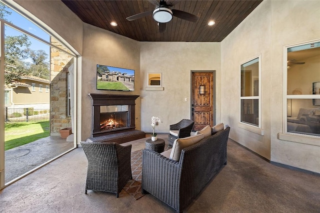 living room featuring a healthy amount of sunlight, ceiling fan, and wood ceiling