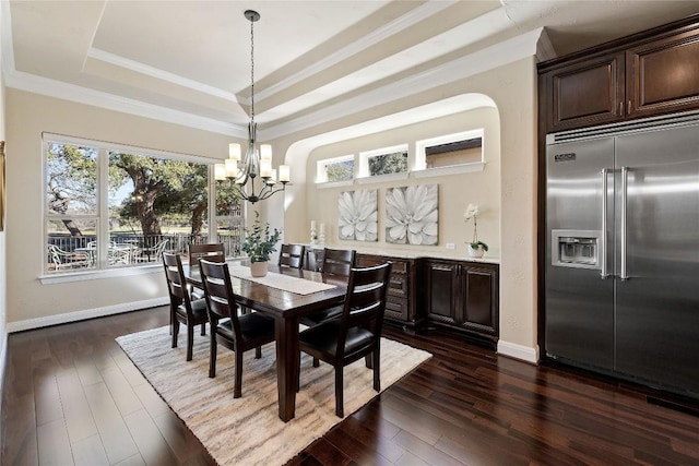 dining space featuring a tray ceiling, crown molding, dark hardwood / wood-style floors, and a notable chandelier