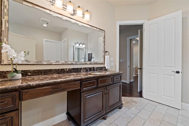 full bathroom featuring baseboards and vanity