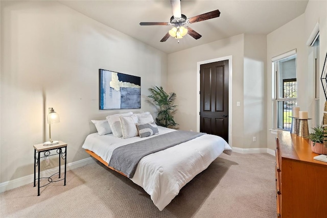 bedroom featuring light colored carpet, ceiling fan, and baseboards