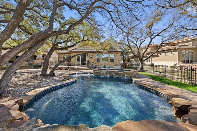 view of swimming pool featuring fence, a patio, and a pool with connected hot tub