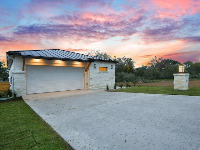 garage at dusk with a lawn