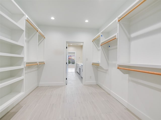 walk in closet with light tile floors