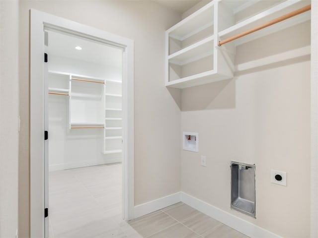 laundry area with hookup for an electric dryer, light tile floors, and hookup for a washing machine