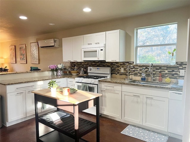 kitchen featuring white appliances, light stone countertops, white cabinetry, and tasteful backsplash