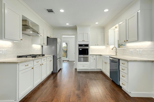 kitchen with wall chimney exhaust hood, dark wood-type flooring, stainless steel appliances, crown molding, and white cabinets