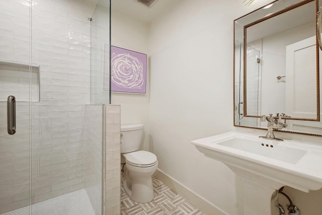 bathroom with toilet, tile patterned floors, and a shower with door