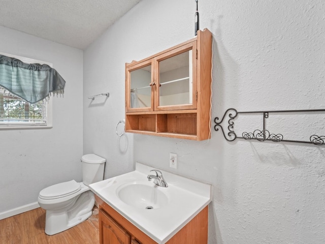 bathroom featuring toilet, vanity, a textured ceiling, and hardwood / wood-style flooring