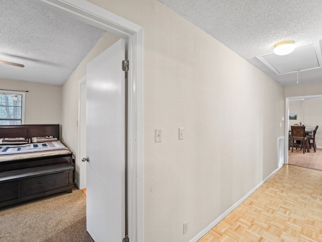 hallway with a textured ceiling and light parquet flooring