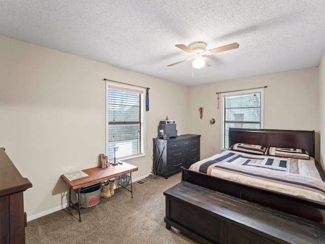 carpeted bedroom with ceiling fan and a textured ceiling