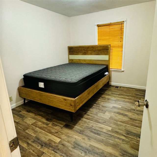 bedroom with dark wood-type flooring