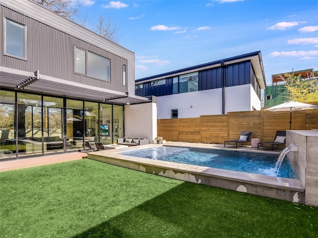 back of property with a lawn, a fenced in pool, a patio, and pool water feature