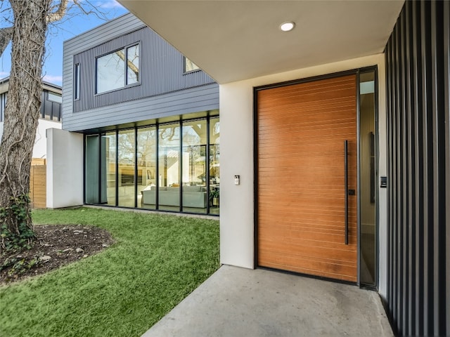 doorway to property featuring a lawn