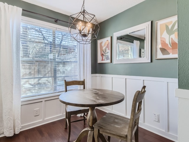 dining space with dark hardwood / wood-style flooring and an inviting chandelier