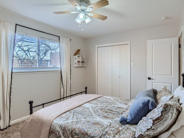 carpeted bedroom featuring a textured ceiling, ceiling fan, and a closet