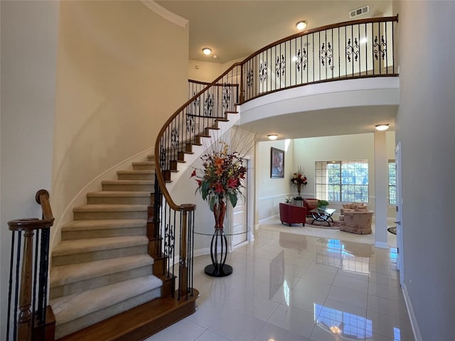 stairs with a high ceiling and tile patterned floors