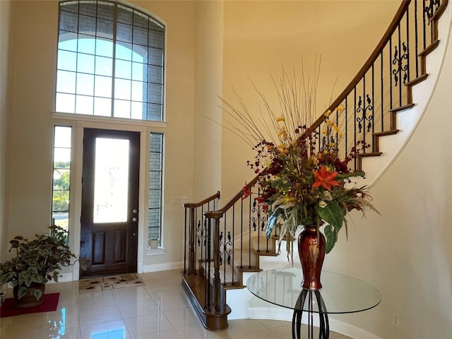 entryway featuring a towering ceiling and light tile patterned flooring