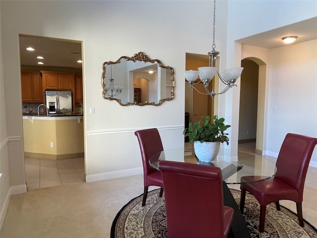 dining room featuring a notable chandelier, light tile patterned floors, and sink