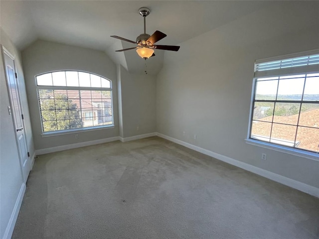 carpeted empty room with vaulted ceiling, plenty of natural light, and ceiling fan