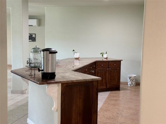 bar with light tile patterned floors, a wall unit AC, and dark stone counters