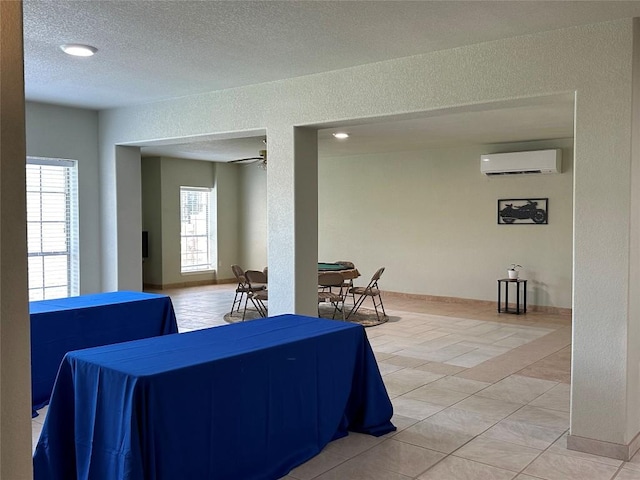 living room featuring tile patterned flooring, a textured ceiling, an AC wall unit, and ceiling fan