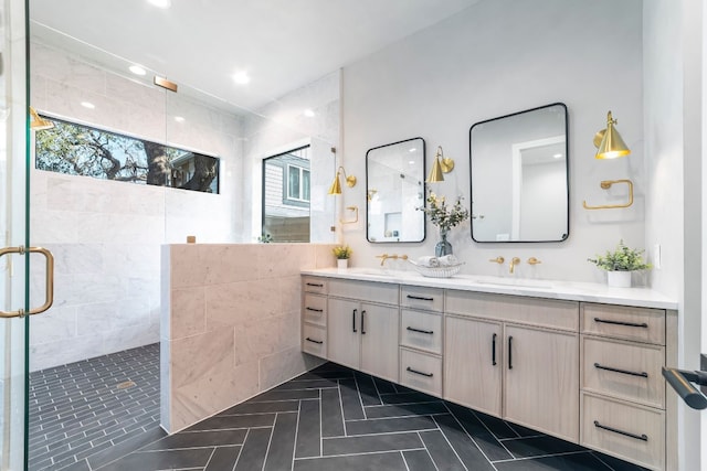 bathroom with a shower with door, vanity, and tile patterned flooring