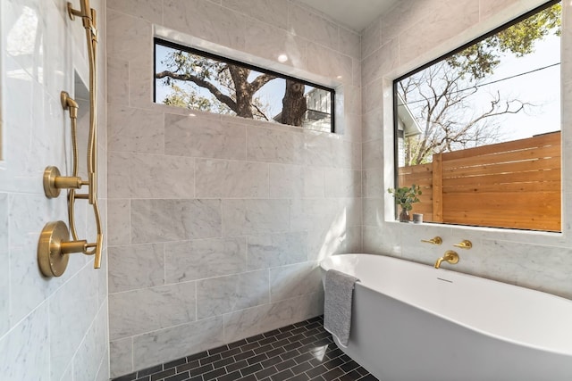 bathroom featuring tile patterned flooring, tile walls, and a tub