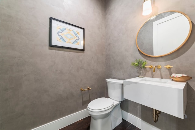 bathroom featuring hardwood / wood-style flooring and toilet