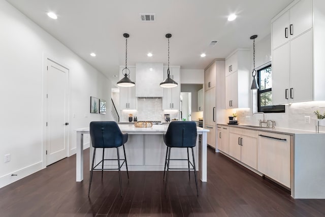 kitchen featuring white cabinets, decorative light fixtures, dark wood-type flooring, and a spacious island