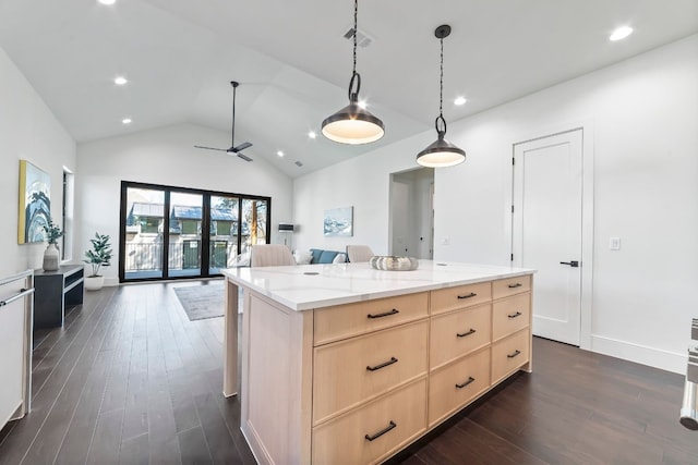 kitchen with light brown cabinets, a center island, light stone counters, dark hardwood / wood-style floors, and lofted ceiling