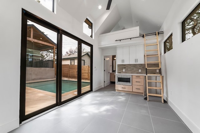 entryway featuring tile patterned flooring and high vaulted ceiling