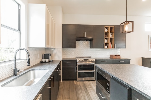 kitchen featuring appliances with stainless steel finishes, hanging light fixtures, tasteful backsplash, and sink