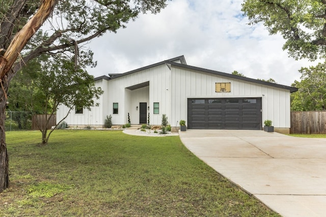 modern farmhouse style home featuring a front yard and a garage