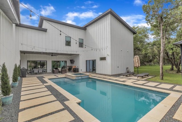 view of swimming pool featuring a patio, a lawn, and an in ground hot tub