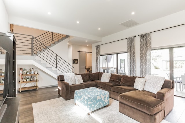 living room featuring plenty of natural light, a barn door, and hardwood / wood-style floors