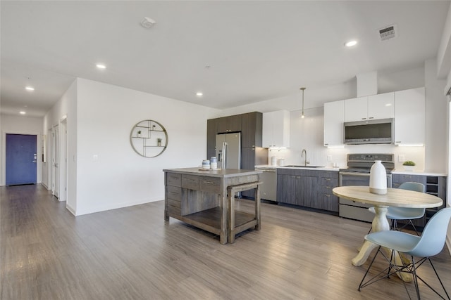 4361 S Congress Ave Unit 408, Austin, TX 78745 - kitchen featuring stainless steel appliances, a sink, light countertops, decorative backsplash, and light wood-type flooring