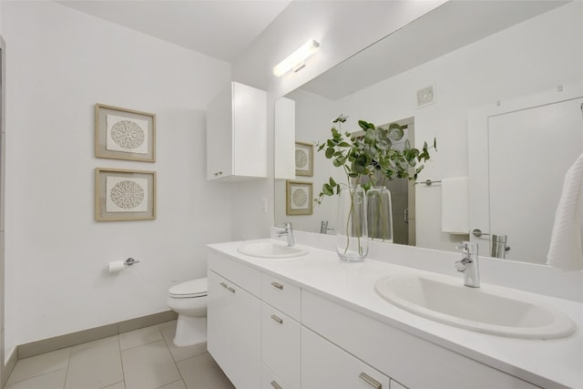 4361 S Congress Ave Unit 408, Austin, TX 78745 - bathroom with toilet, double vanity, baseboards, and tile patterned flooring