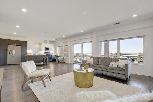 4361 S Congress Ave Unit 408, Austin, TX 78745 - living room featuring plenty of natural light, recessed lighting, wood finished floors, and baseboards