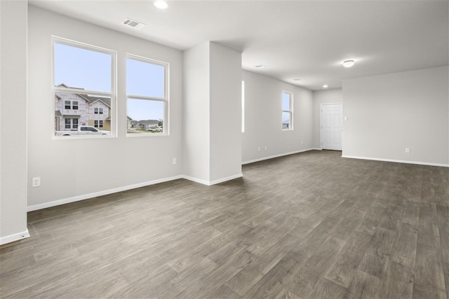 spare room with dark hardwood / wood-style floors and plenty of natural light