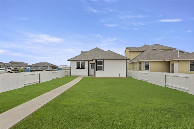 rear view of property featuring a yard