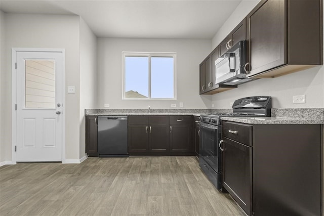 kitchen with dishwasher, sink, black gas range oven, dark brown cabinets, and light hardwood / wood-style floors