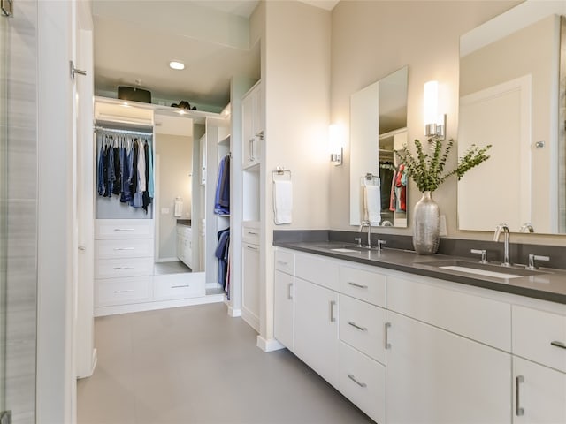 bathroom featuring tile floors, dual sinks, and vanity with extensive cabinet space