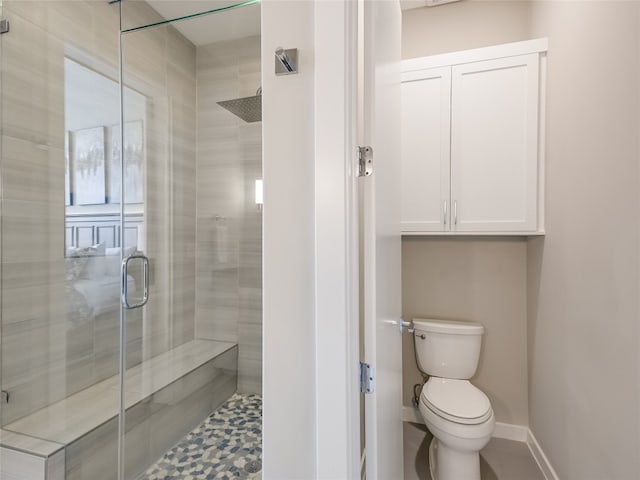 bathroom with walk in shower, toilet, and tile floors