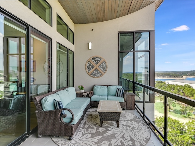 balcony featuring outdoor lounge area and a water view