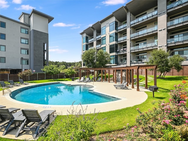 view of pool with a lawn and a patio