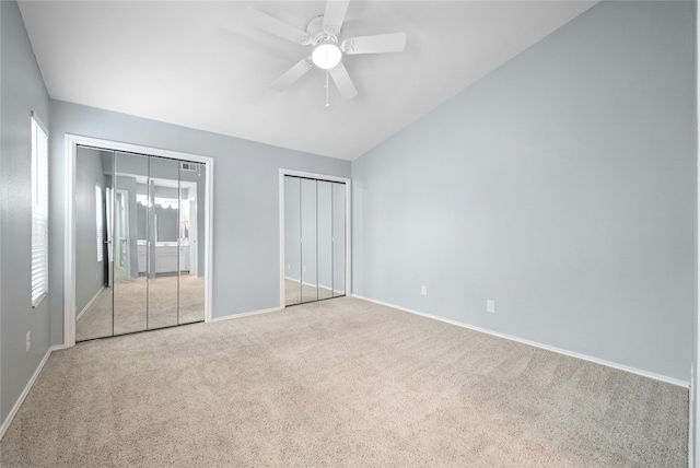 unfurnished bedroom with light carpet, two closets, ceiling fan, and multiple windows